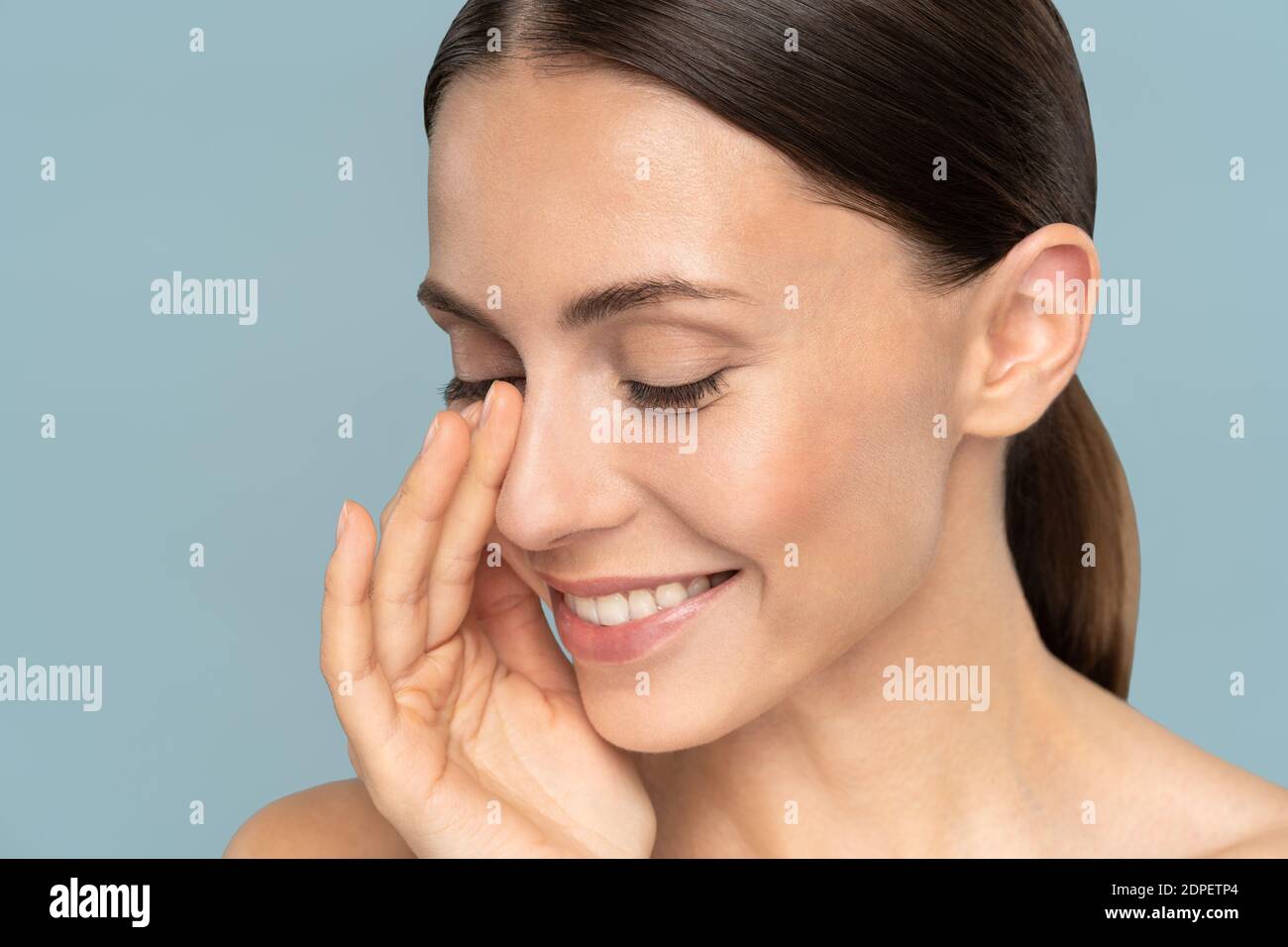 Young woman with natural makeup, combed hair, touching her well-groomed ...