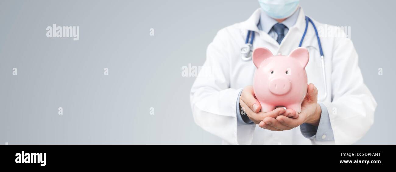 Doctor holding piggy bank. Health costs, health insurance concept Stock Photo