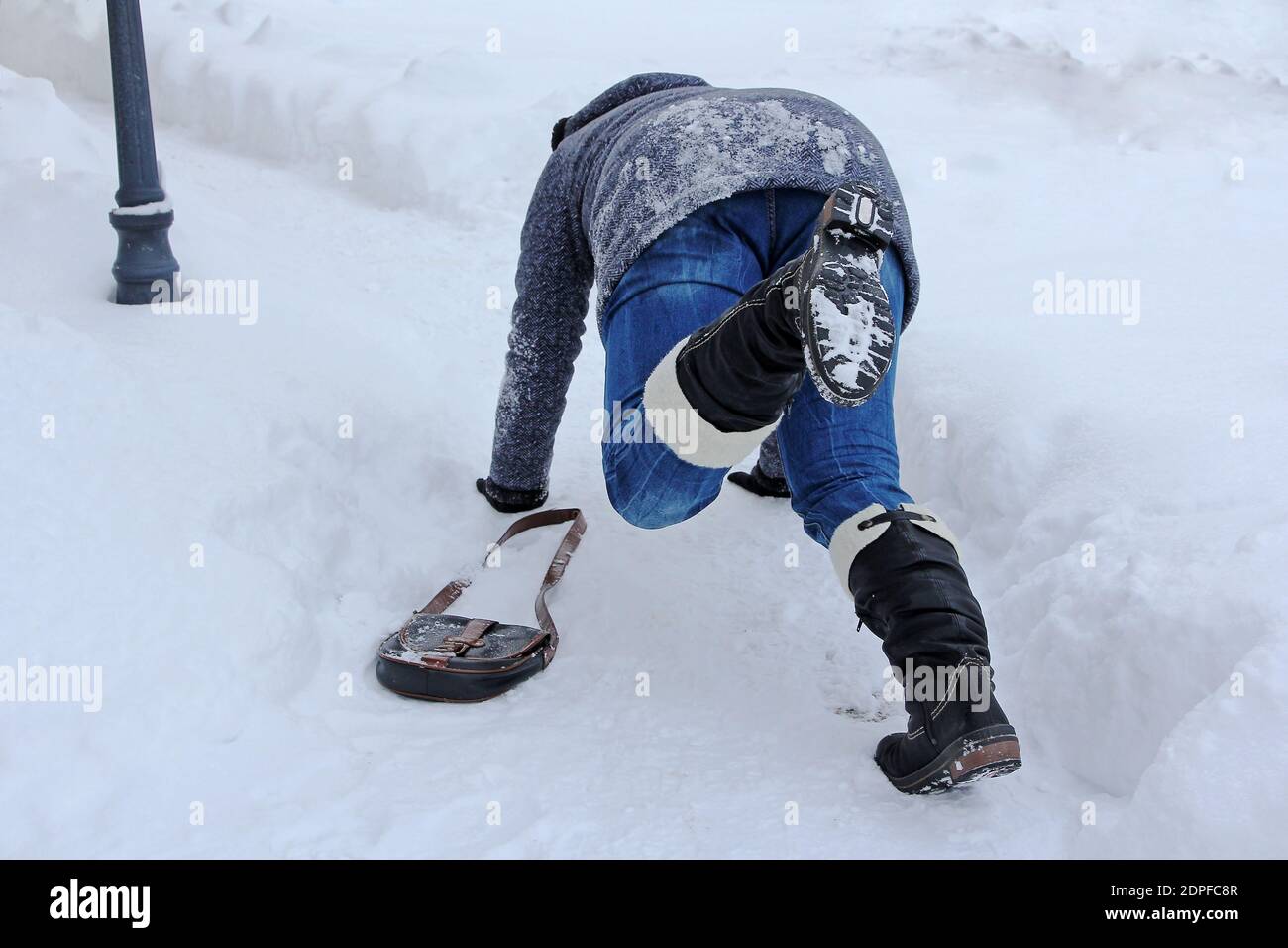 Accident danger in winter. A woman slips out on the smooth street Stock Photo