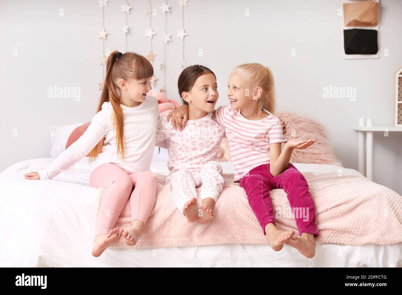 Cute little girls sitting in pajamas at home Stock Photo - Alamy
