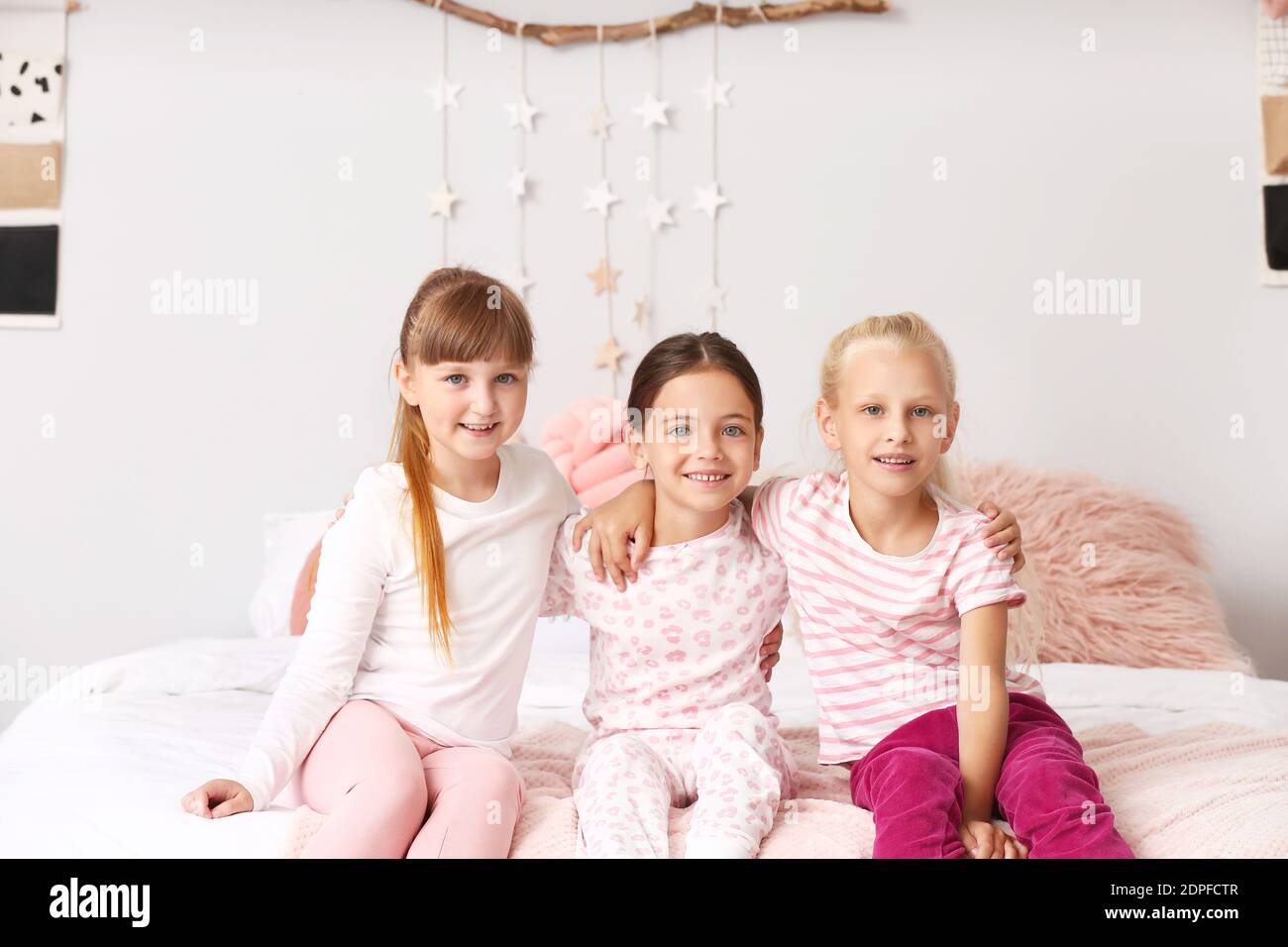 Cute little girls sitting in pajamas at home Stock Photo - Alamy