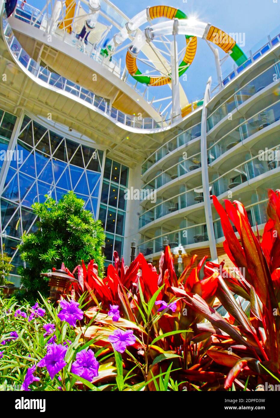 Water slides on top of Symphony of the Seas cruise ship viewed from flowers growing garden in Central Park. Stock Photo