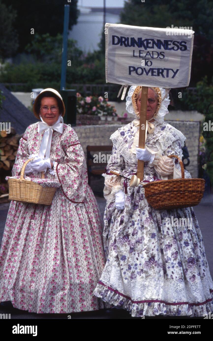 Two women in olden times costumes carrying a placard 'Drunkenness Leads to Poverty' at festival in Broadstairs, Kent England, 2000 Stock Photo