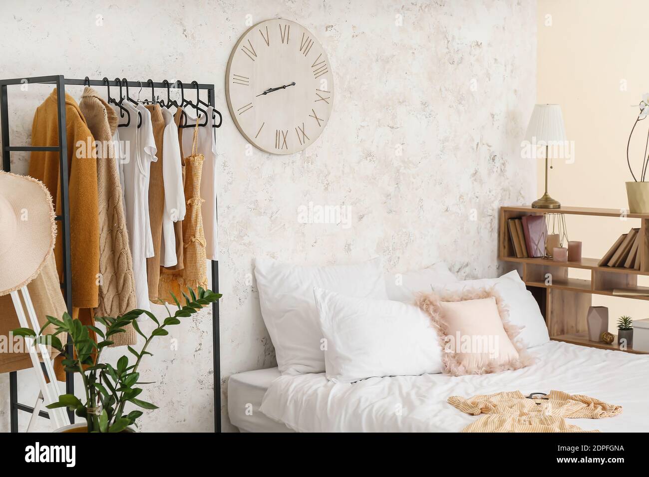 Interior of stylish bedroom with clothes rack Stock Photo - Alamy