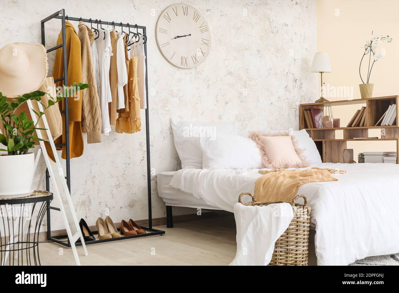 Interior of stylish bedroom with clothes rack Stock Photo - Alamy
