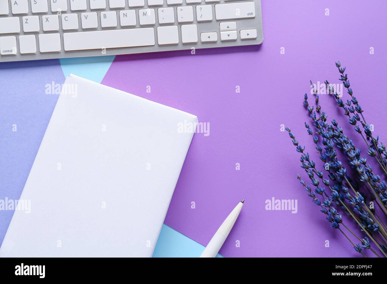 Composition with blank book and computer keyboard on color background Stock Photo