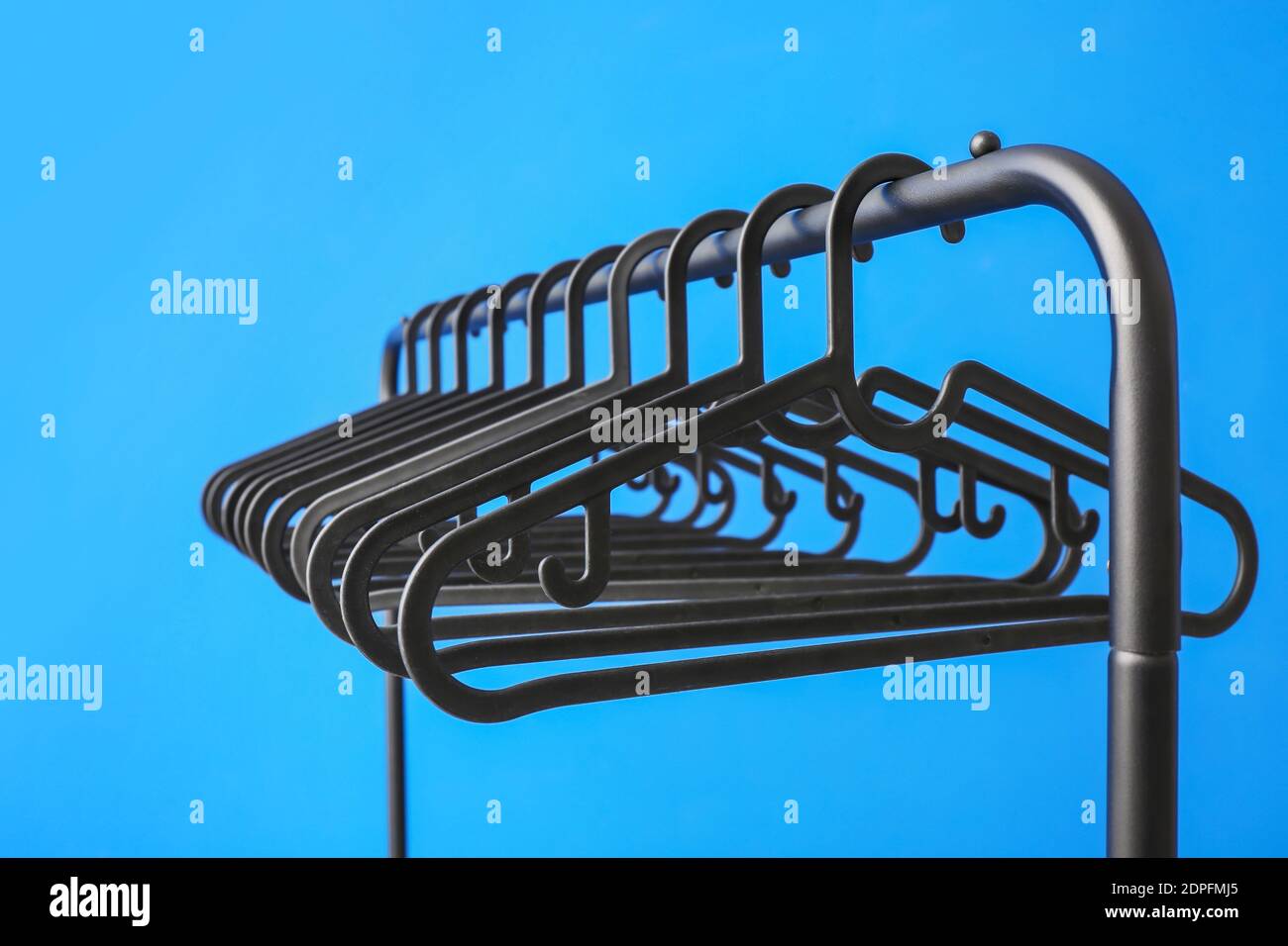 Rack with clothes hangers on color background Stock Photo - Alamy