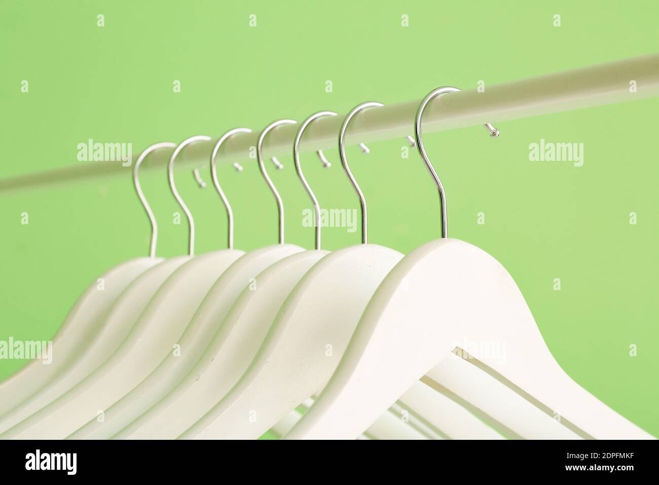 Rack with clothes hangers on color background, closeup Stock Photo - Alamy