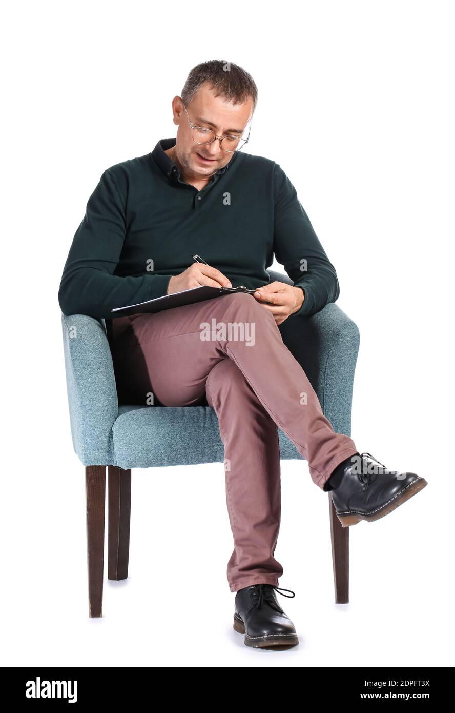 Male psychologist sitting in armchair against white background Stock