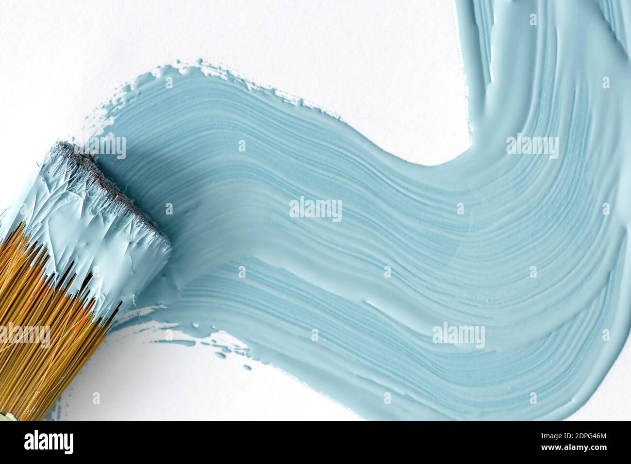 Blue paint and close up view of paint brush on white background Stock Photo