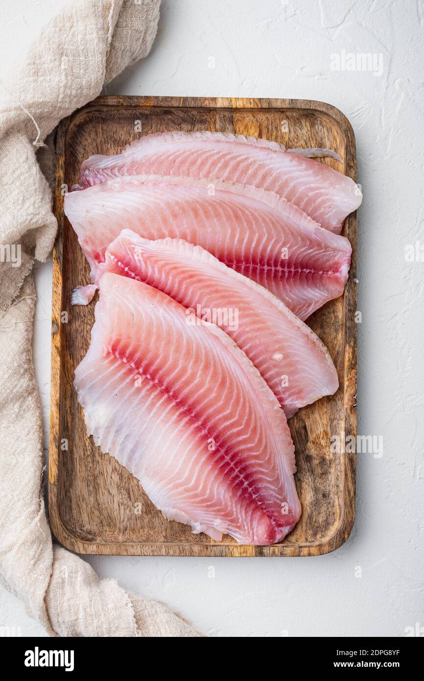 Raw white fish fillet cuts, on white background, top view Stock Photo ...