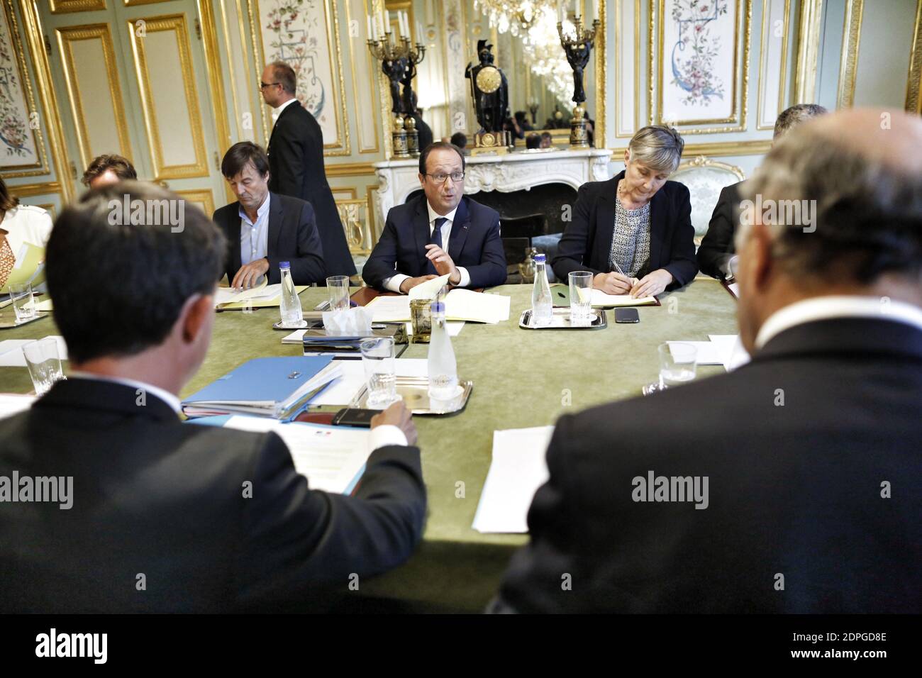 French President Francois Hollande (C) presides over a ministerial meeting including Prime Minister Manuel Valls (foreground, L), Minister of Ecology, Sustainable Development and Energy Segolene Royal (unpictured), Minister of Foreign Affairs and International Development Laurent Fabius (foreground, R), environmental activist and President Hollande's special envoy for the protection of the planet Nicolas Hulot (background, L) and COP21 special representative Laurence Tubiana (background, R), in preparation for the COP21 Climate Conference to be held in Paris in December 2015, at the Elysee Pal Stock Photo