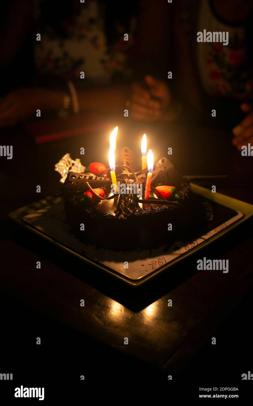 Birthday chocolate cake with burning candles in the dark room Stock