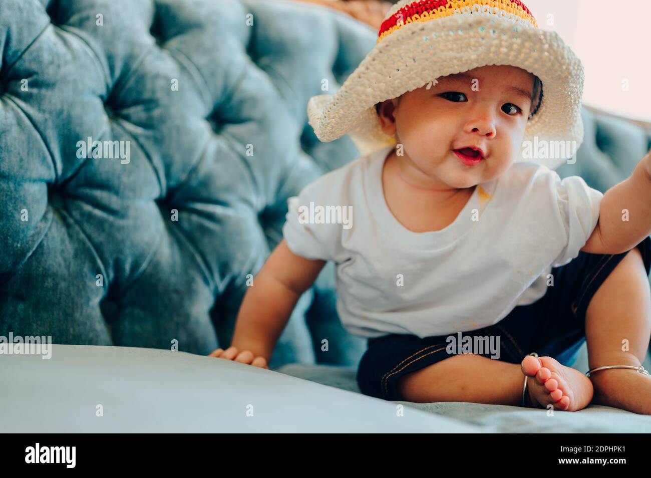 Portrait Of Smiling Baby Boy Sitting On Bed Stock Photo - Alamy