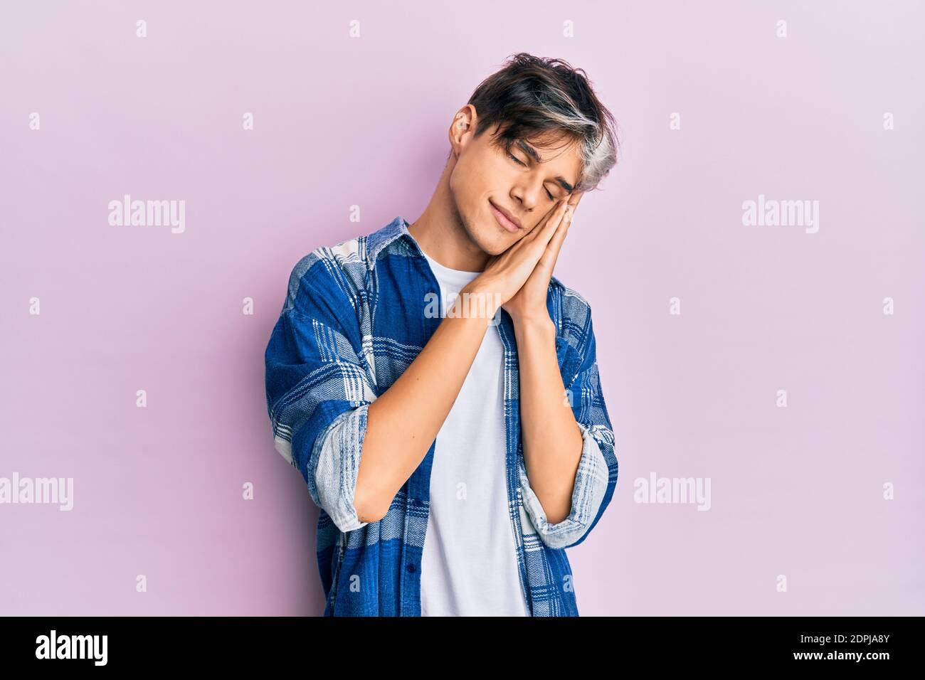 Young hispanic man wearing casual clothes sleeping tired dreaming and ...