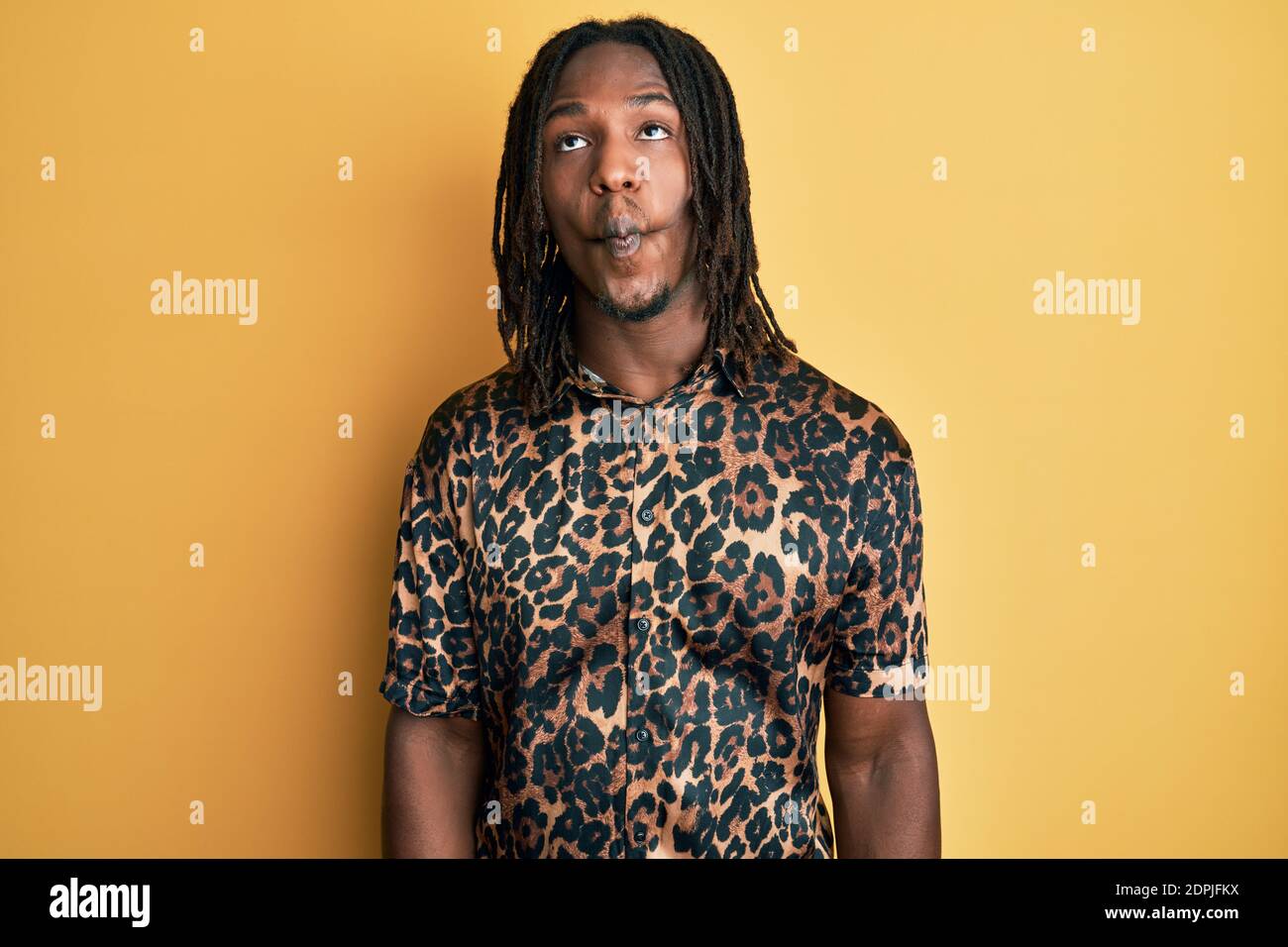African american man with braids wearing leopard animal print shirt making fish face with lips, crazy and comical gesture. funny expression. Stock Photo
