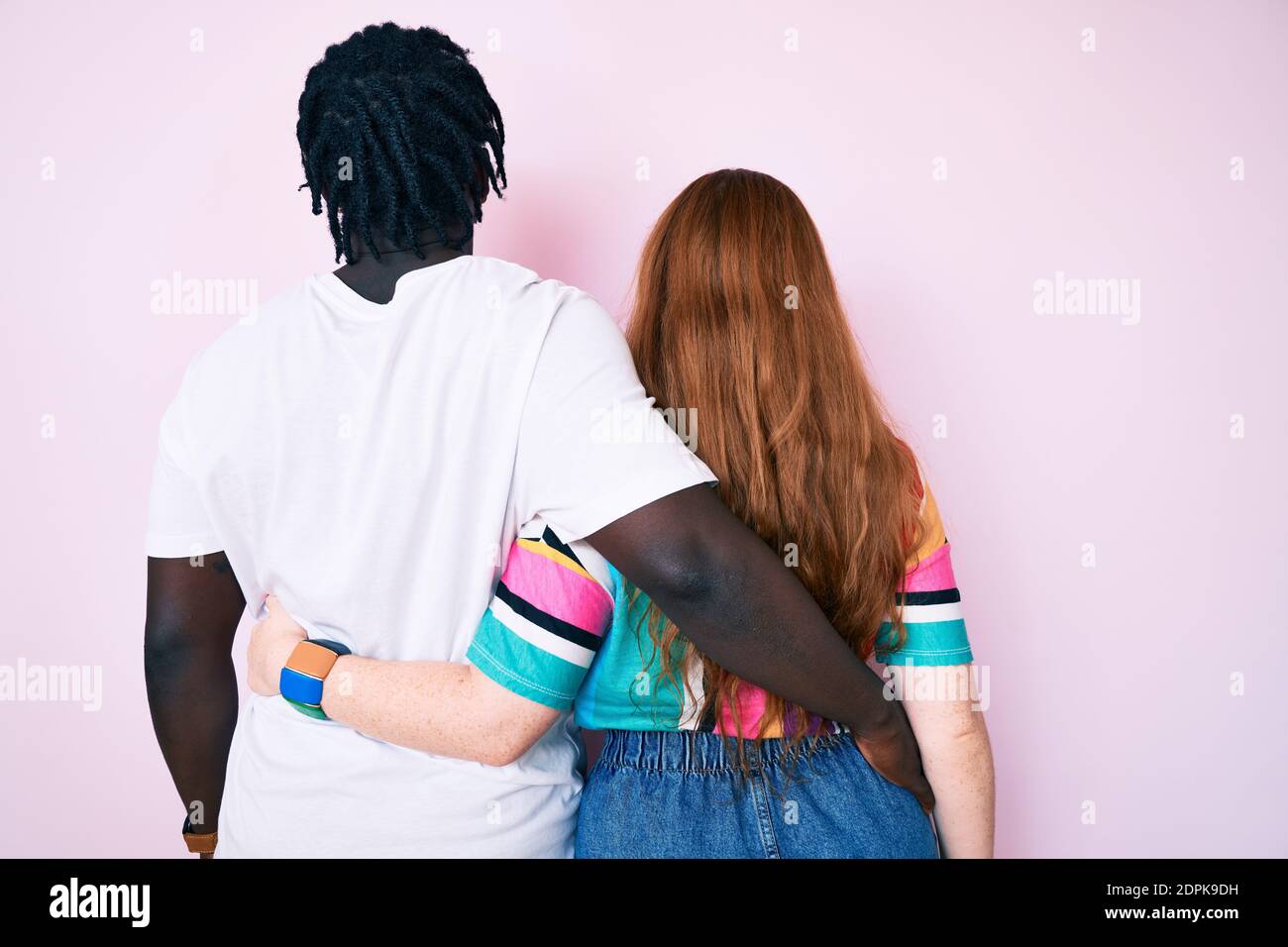 Interracial couple wearing casual clothes hugging oneself happy and positive from backwards. self love and self care Stock Photo
