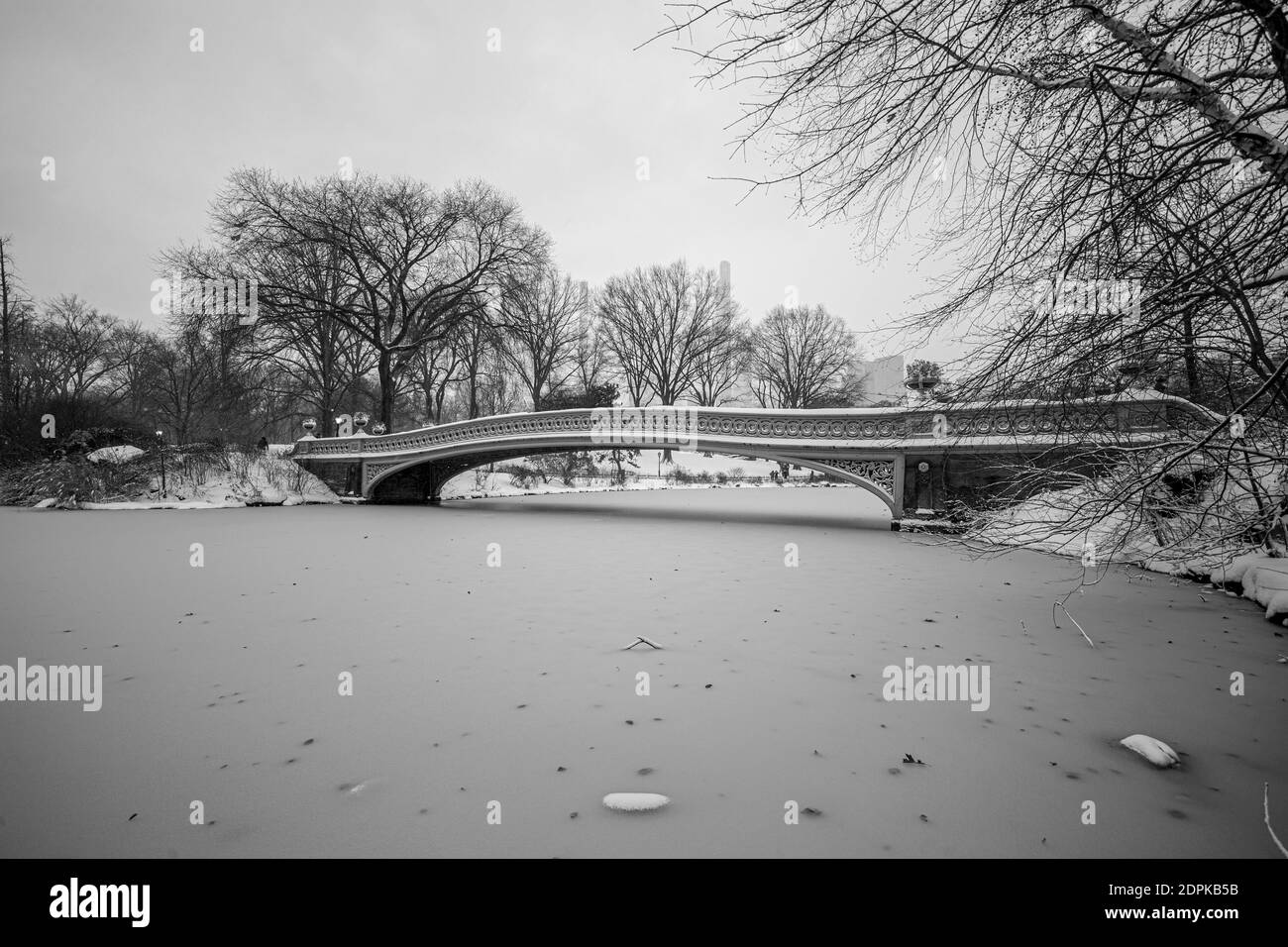 A Bow Bridge is covered in snow near the Lake in Central Park, New York City Stock Photo