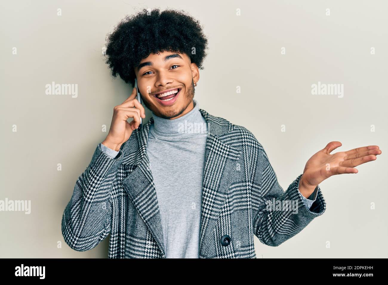 Young african american man with afro hair having conversation talking on  the smartphone celebrating achievement with happy smile and winner  expression Stock Photo - Alamy