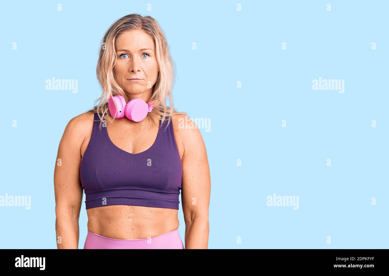 Middle age fit blonde woman wearing gym clothes and using headphones  depressed and worry for distress, crying angry and afraid. sad expression  Stock Photo - Alamy