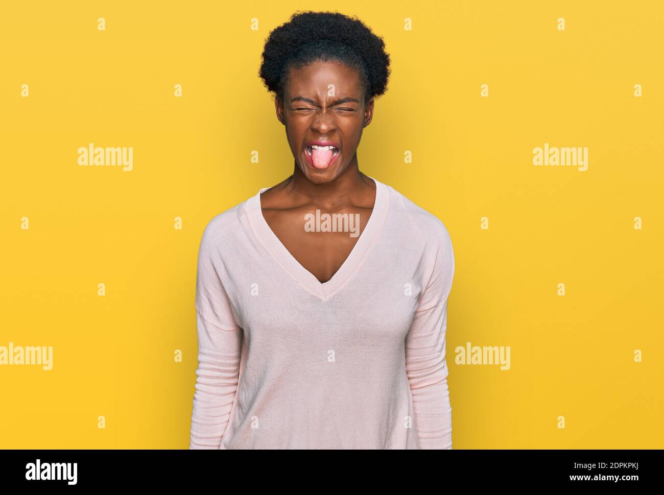 Young african american girl wearing casual clothes sticking tongue out ...