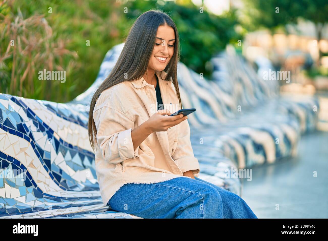 Young hispanic girl smiling happy using smartphone at the park Stock ...