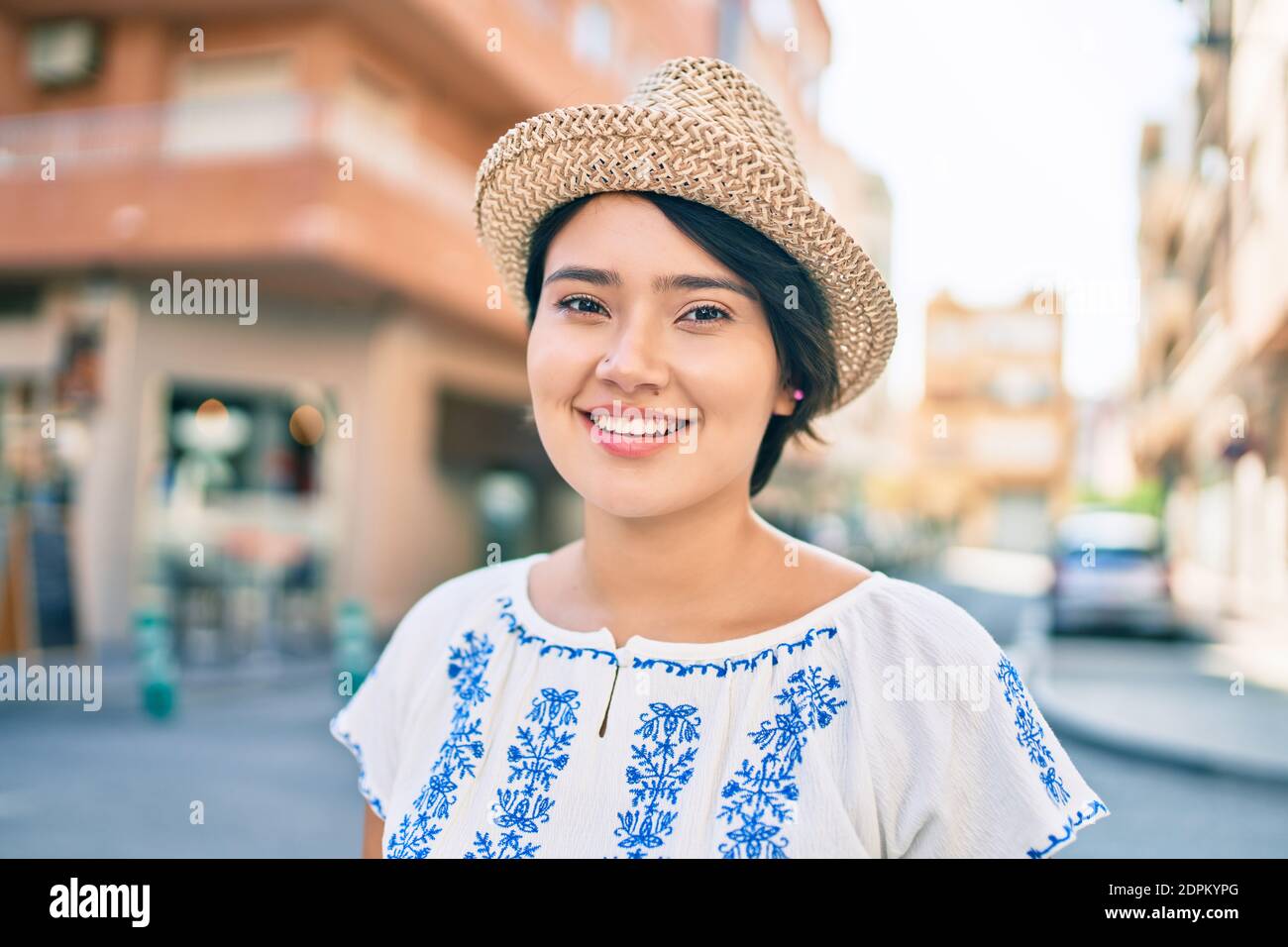 Young latin tourist girl on vacation smiling happy walking at the city ...