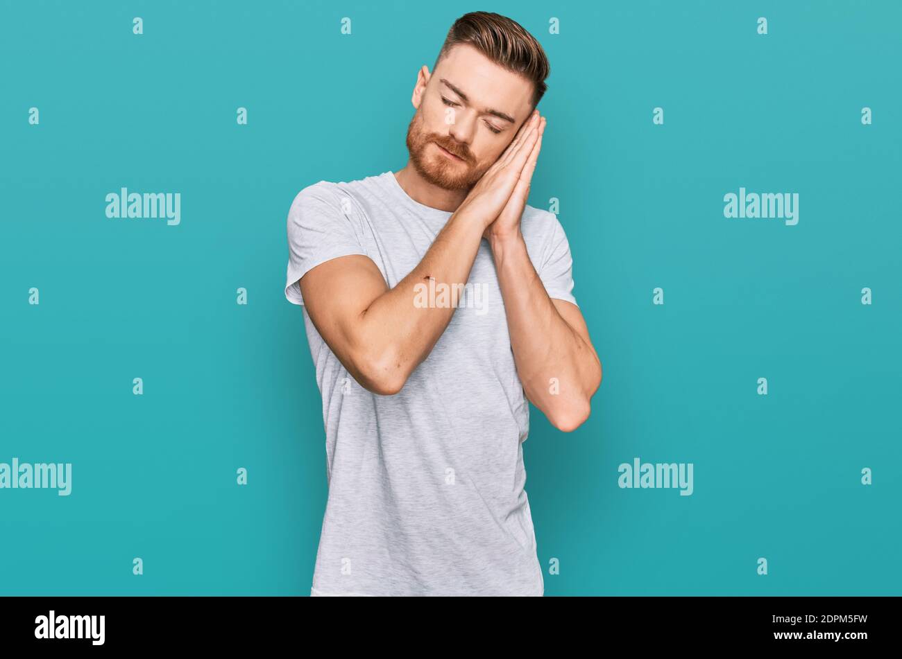 Young redhead man wearing casual grey t shirt sleeping tired dreaming ...