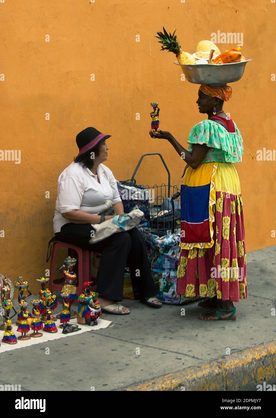Palenquera has a laugh at a figurine of herself intended as tourist merchandise in Cartagena de Indias Stock Photo