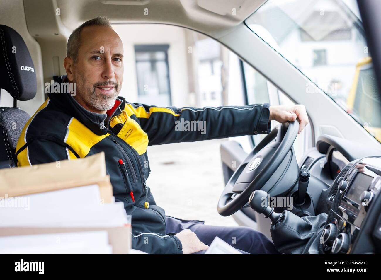 March, Germany. 10th Dec, 2020. Dany Bousquet sits in his van, which is  parked in the yard of Deutsche Post's March delivery base. Bousquet was a  professional ice hockey player until 2011,