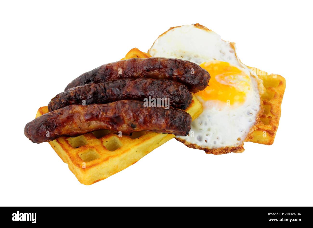 Grilled pork sausages and fried egg on a potato waffle isolated on a