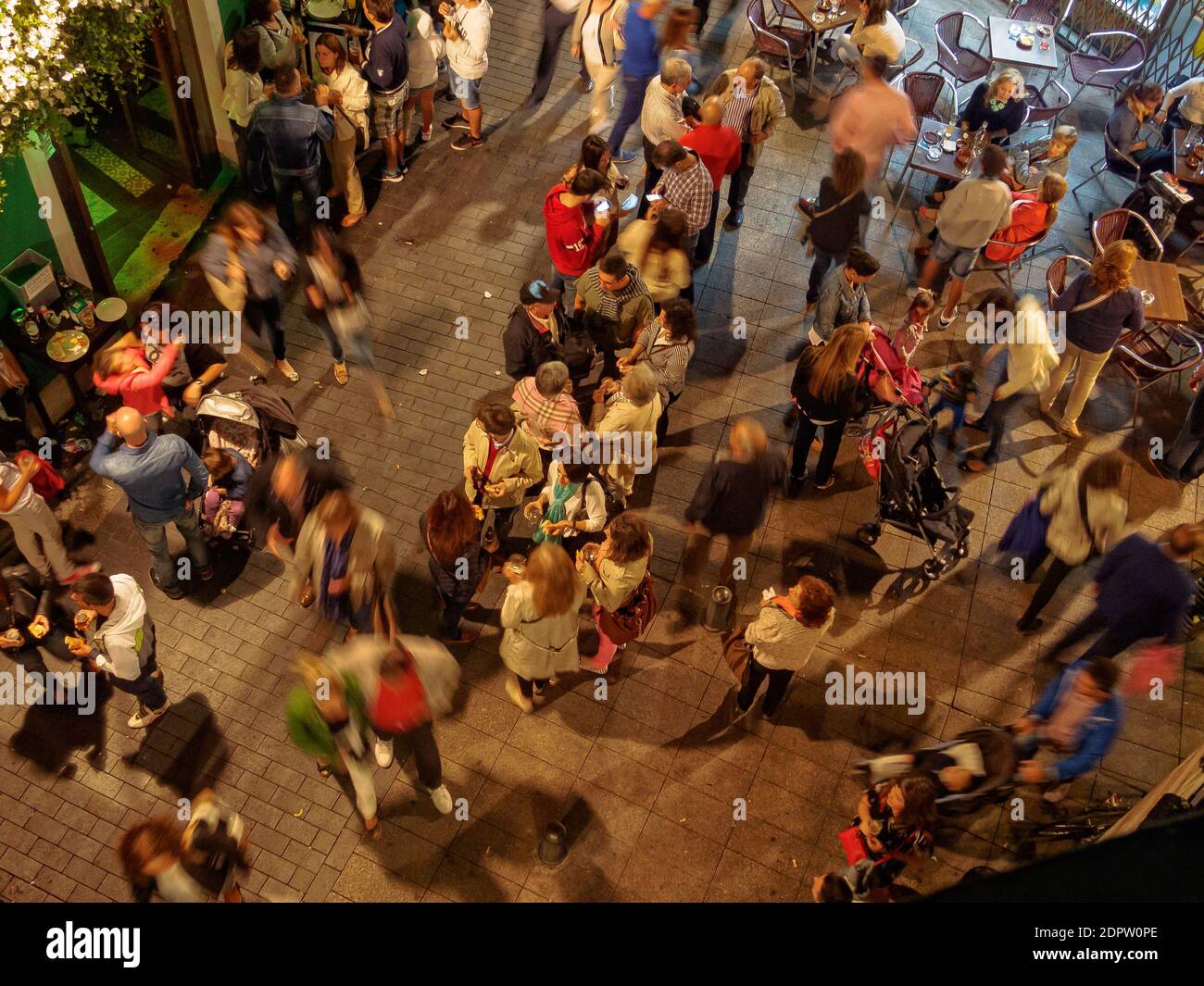 People of all ages enjoy a a party on the Torres de Omana Square on a mild autumn evening - Leon, Castile and Leon, Spain Stock Photo