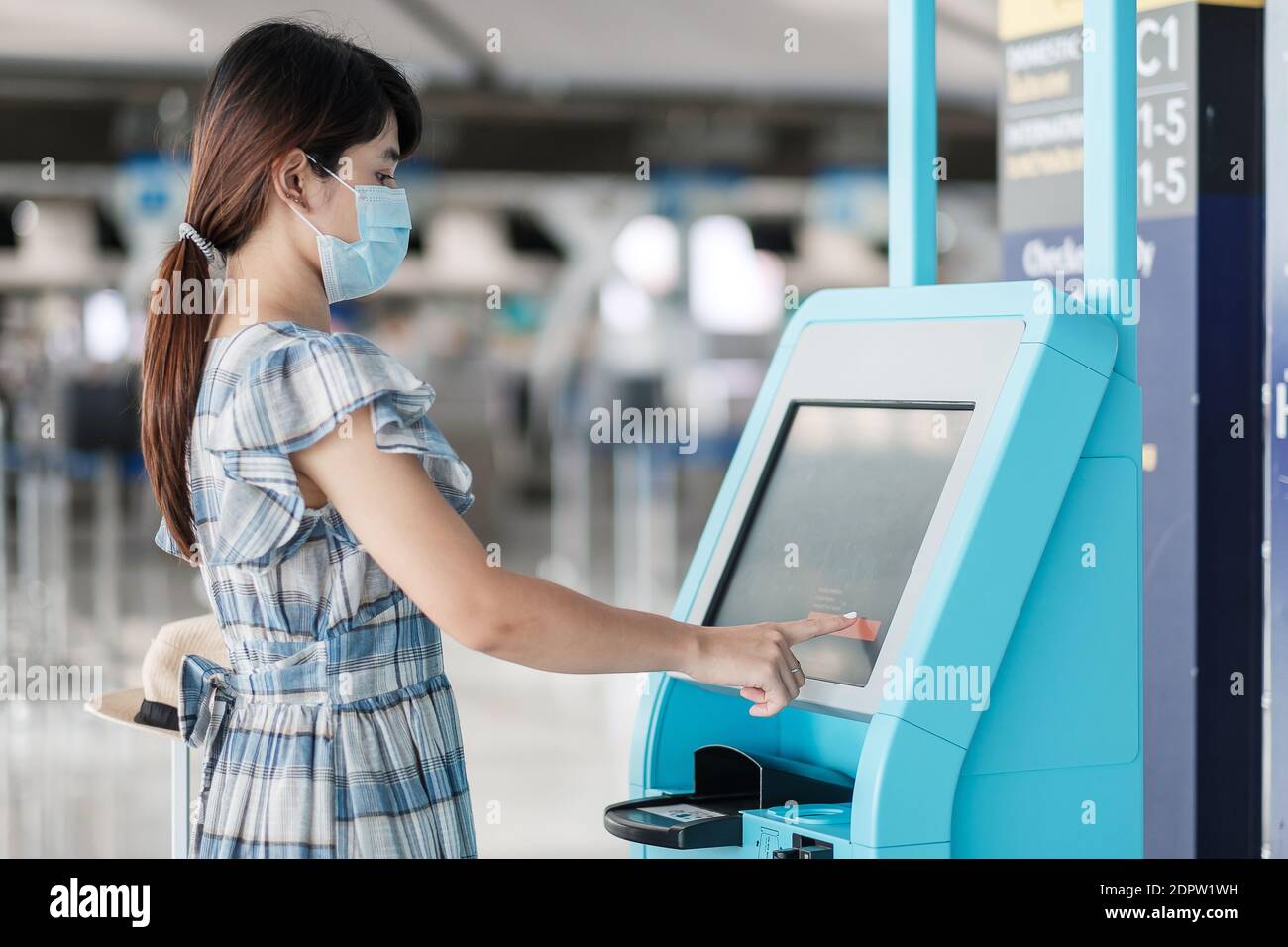 https www alamy com side view of woman wearing mask using atm machine at airport image392700829 html