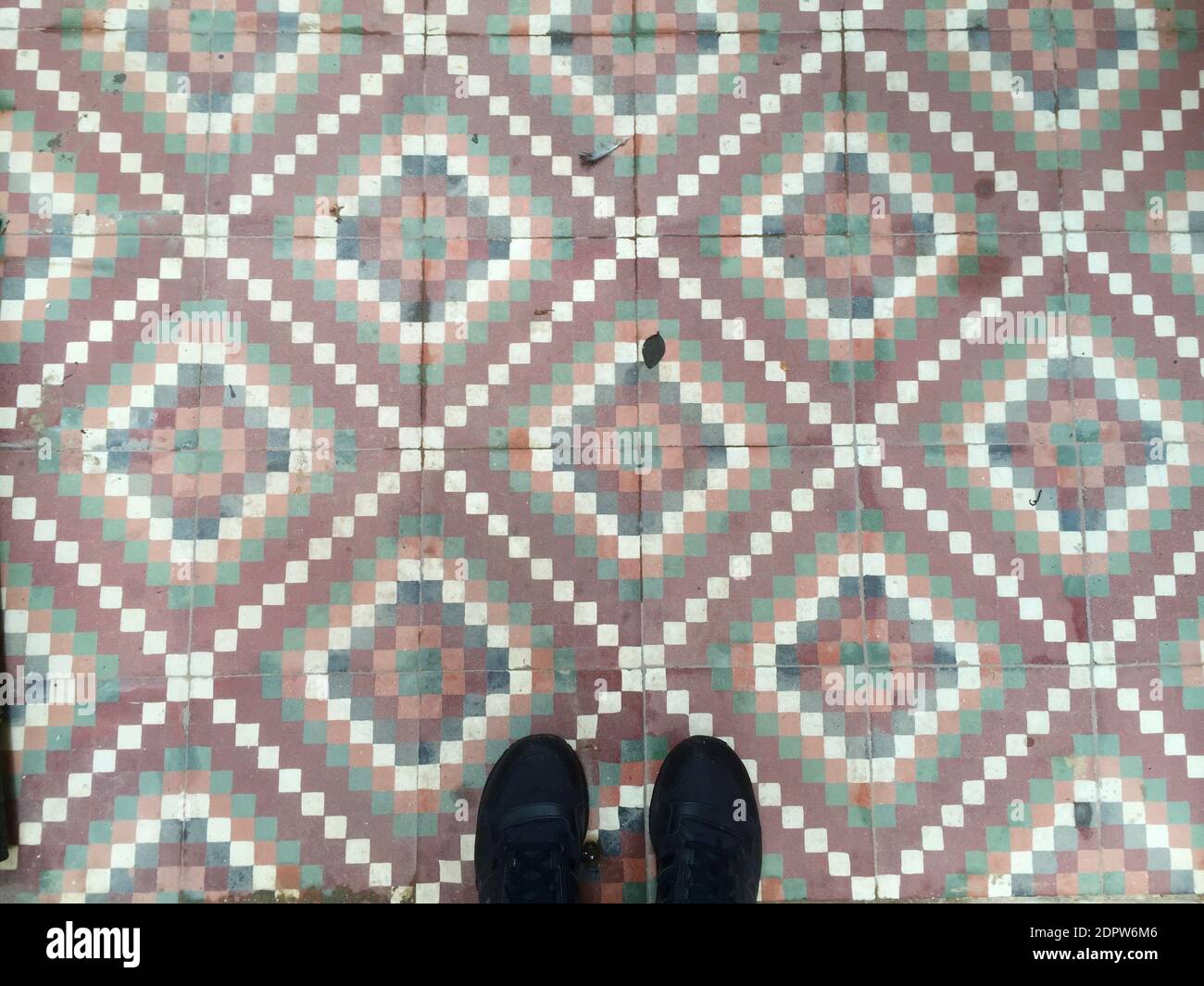 Low Section Of Man Standing On Tiled Floor Stock Photo
