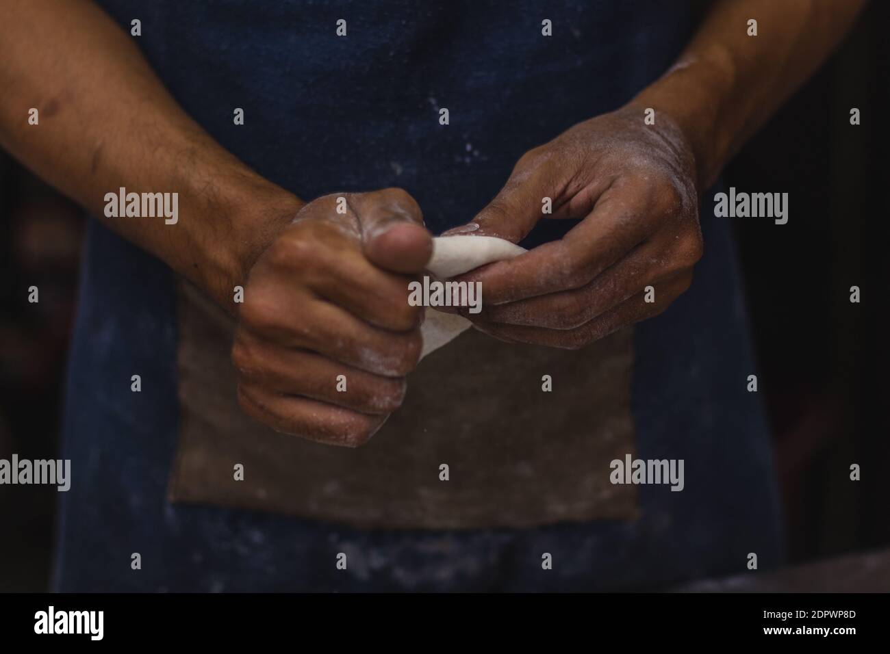 Midsection Of Man Preparing Food Against Black Background Stock Photo