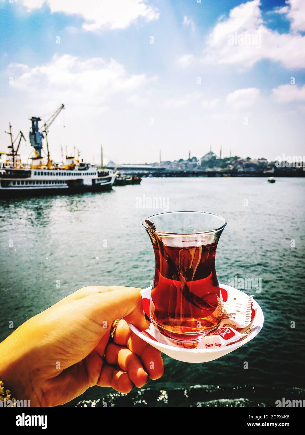 Person Holding Tea Against Sky Stock Photo