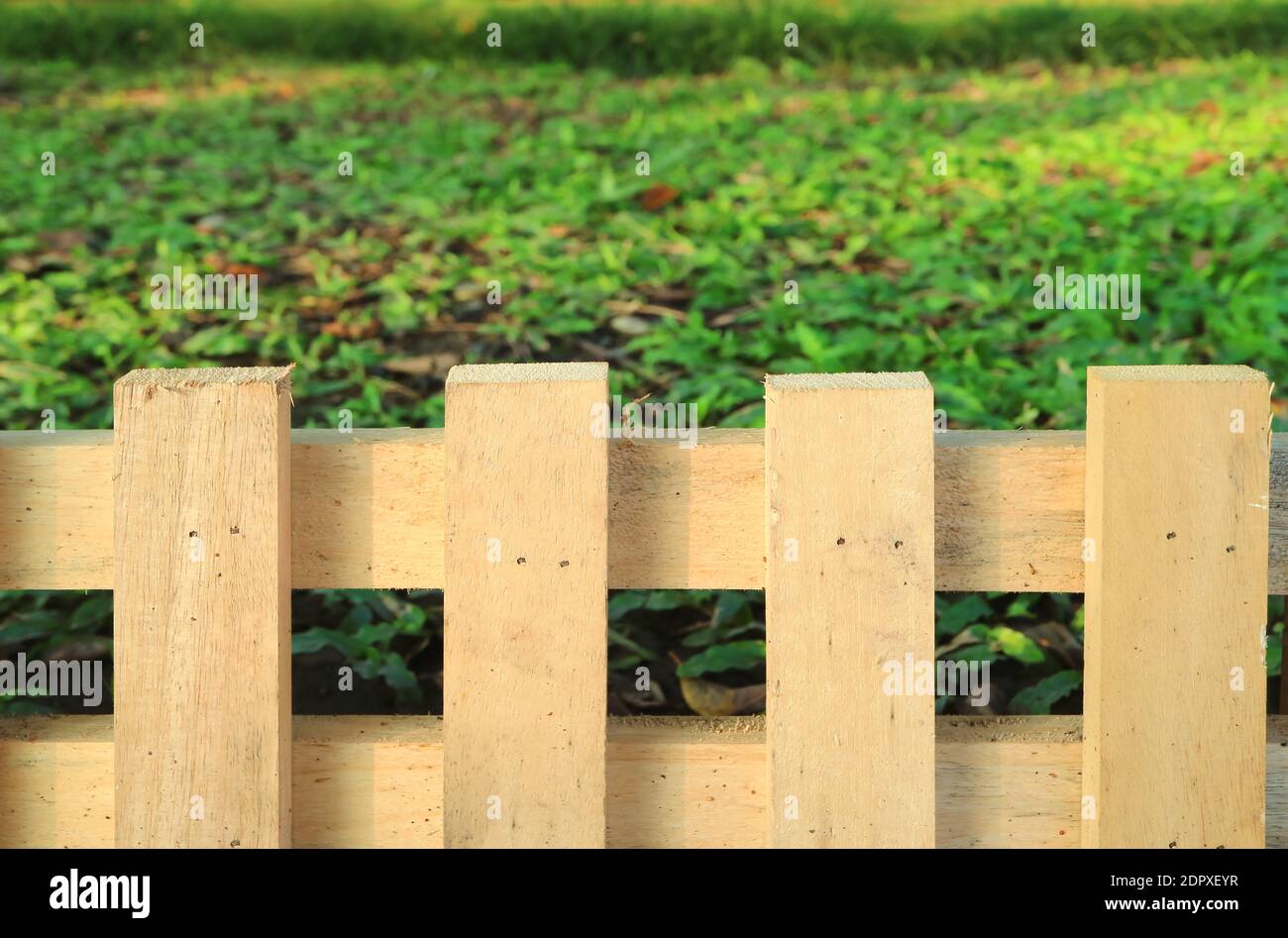 Rustic wooden fence with green grass lawn in background Stock Photo - Alamy