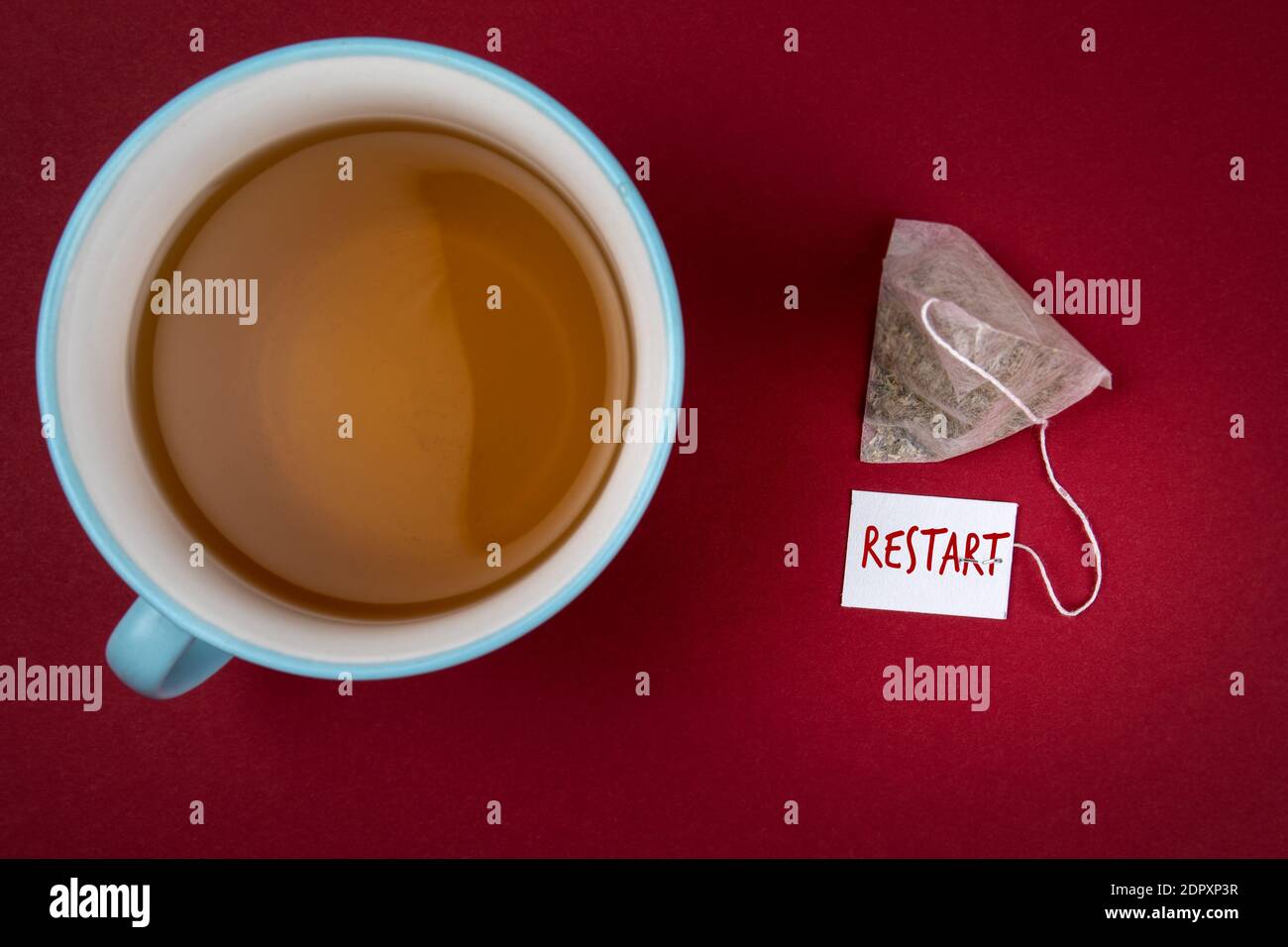 RESTART. Business concept. Tea bag and mug on a red background. Stock Photo