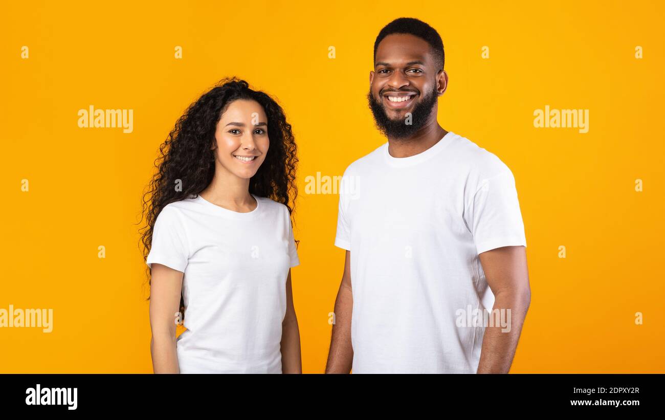 Multiethnic Couple Posing Standing Over Yellow Studio Background, Panorama Stock Photo