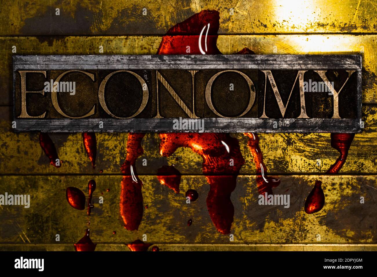 Economy text bleeding on grunge textured copper and gold background with copy space symbolizing economic collapse Stock Photo