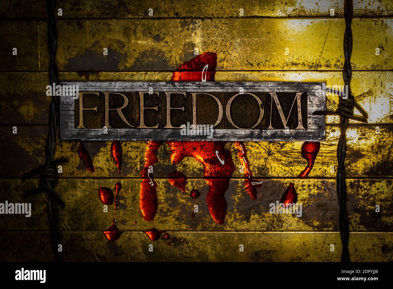 Freedom text bleeding lined by barbed wire on grunge textured copper and gold background with copy space symbolizing economic collapse Stock Photo