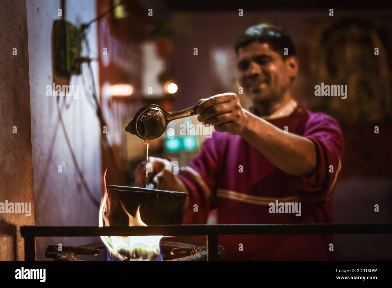 Indian Man Making Tea In Restaurant Stock Photo