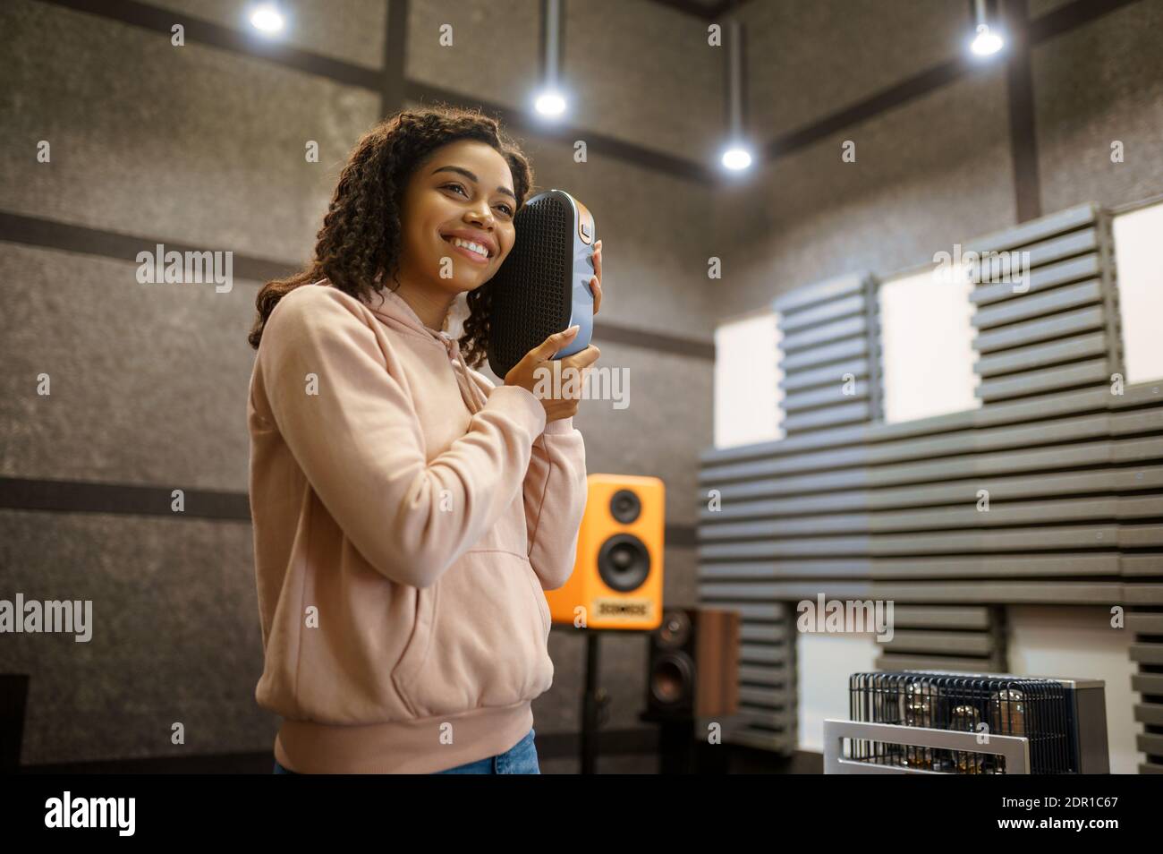 Smiling woman holds sound speaker in store Stock Photo