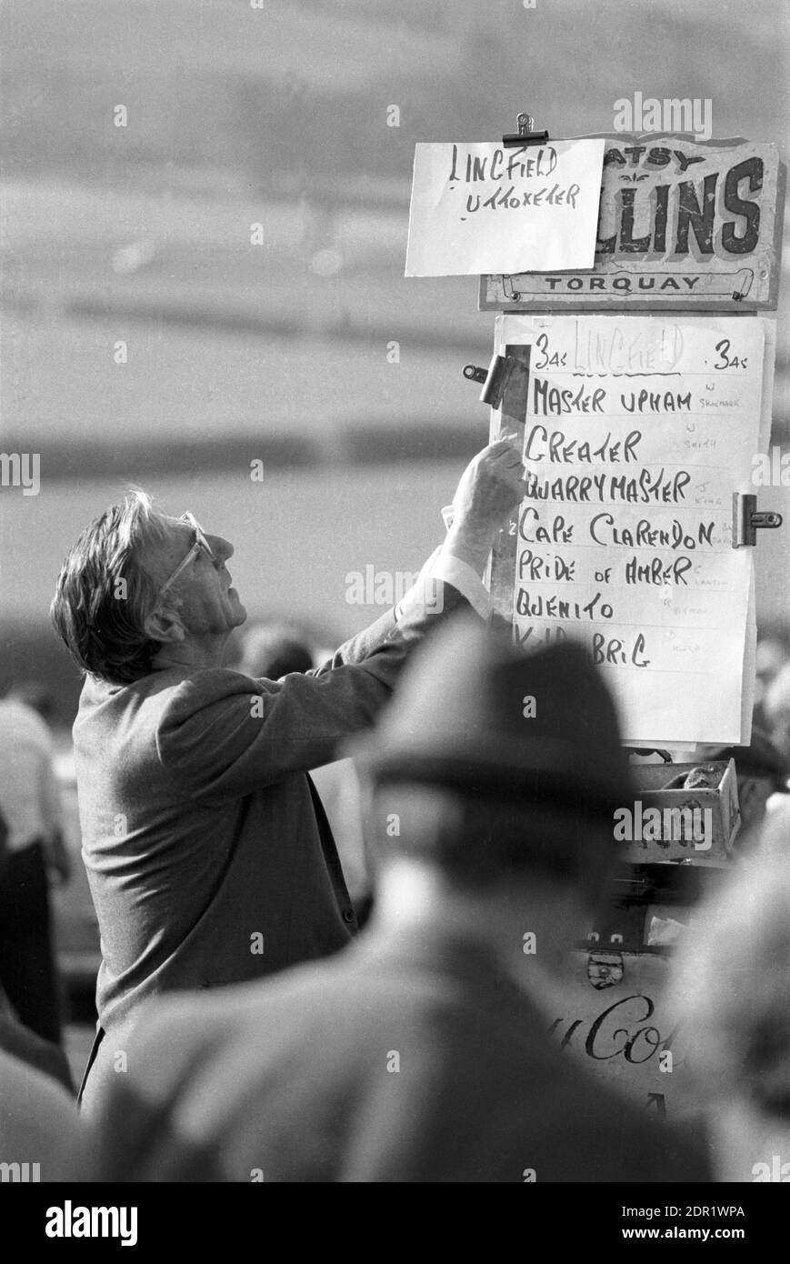 UK, England, Devonshire, Buckfastleigh, 1972. Point-to-Point races were held at  Dean Court on the Dean Marshes, close to the A38 between Plymouth and Exeter. A bookmaker with the latest list of runners at Lingfield, Uttoxeter in the 3.45. Stock Photo