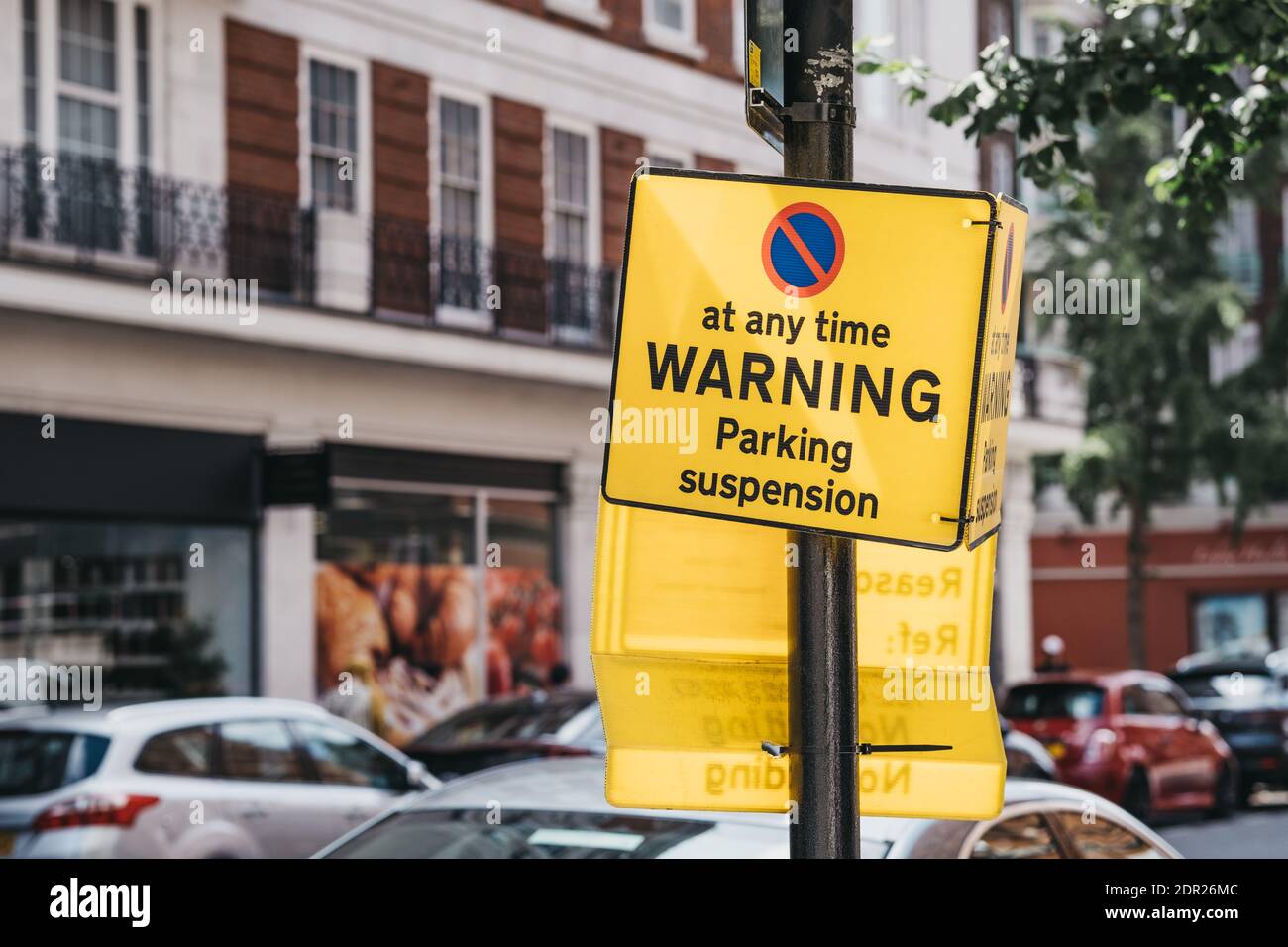 Yellow Warning Parking Suspension Sign On A Residential Street In