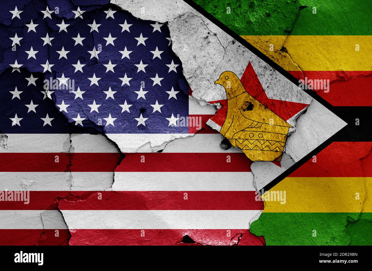 flags of USA and Zimbabwe painted on cracked wall Stock Photo