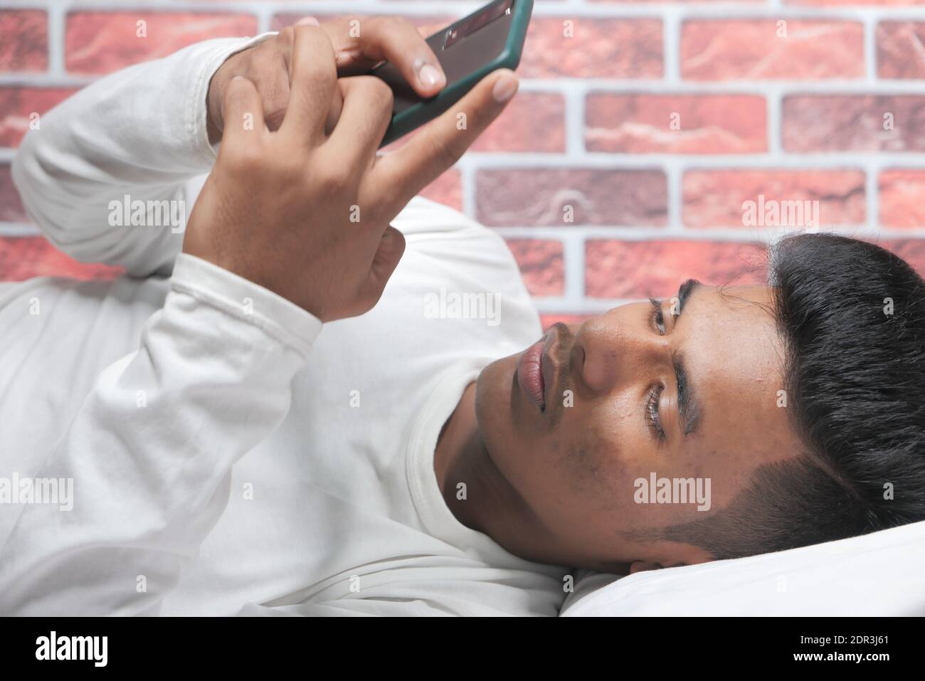 young man on bed using smart phone at night  Stock Photo