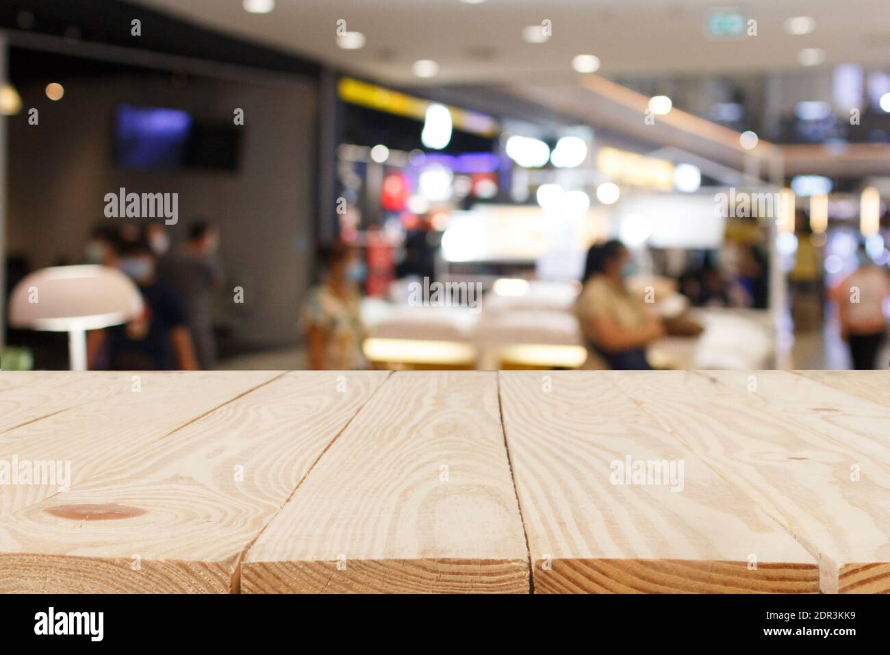 wooden table in front of abstract blurred in shopping mall background ...