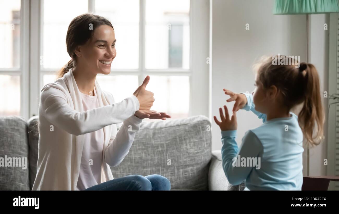 Close up mother and little deaf daughter speaking sign language Stock Photo