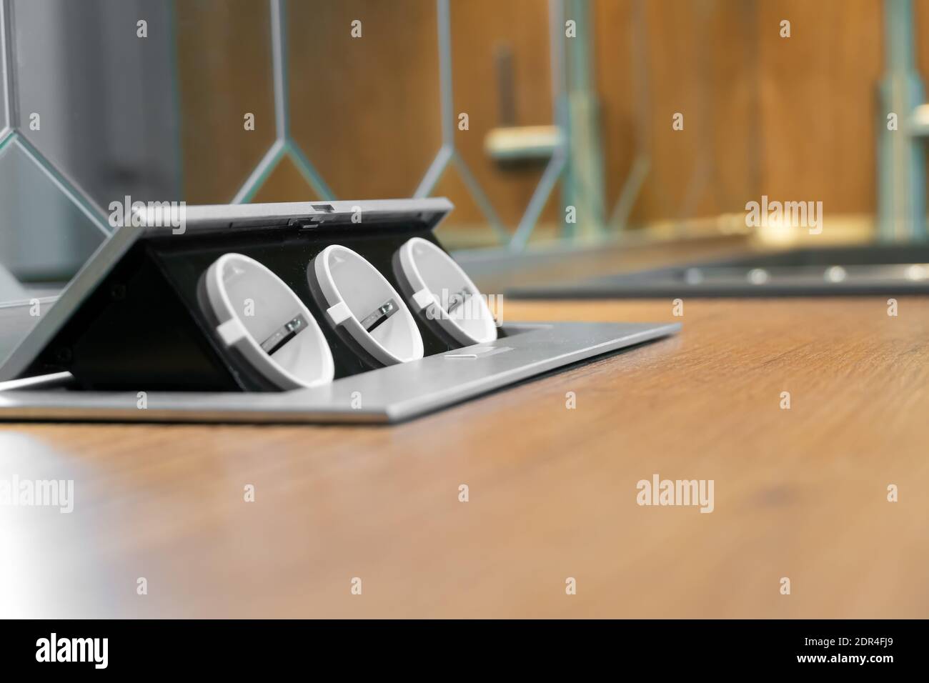 Three hidden sockets on a wooden kitchen countertop closeup, copy